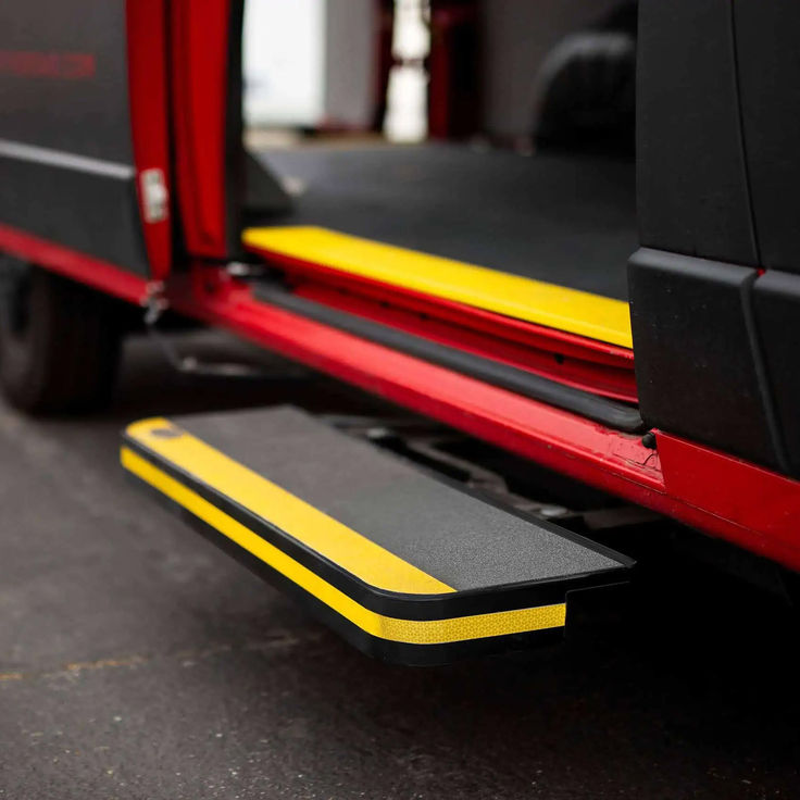 the back end of a red truck with yellow and black stripes on it's sides