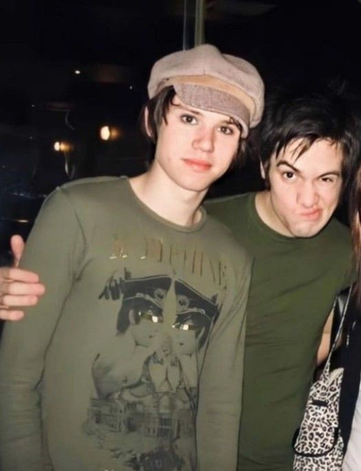 three people posing for the camera with one person wearing a hat and another in a green shirt