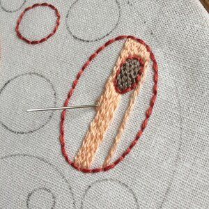 a close up of a piece of fabric with a needle in the middle and some circles around it