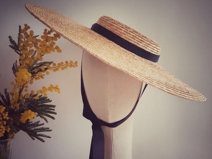 This is a natural straw hat with a shallow crown and a large brim. A classic summer hat perfect for any occasion. The hat is free size and attaches with a discreet millinery elastic, worn around the back of the head. It also has black grosgrain ribbons attached on both sides of the inside belt. These can be tied under the chin, or backside of your neck. Height of the crown:4cm Width of the brim: 13,5 cm Elegant Straw Hat With Flat Crown For Beach, Elegant Natural Straw Hat Bands, Fitted Flat Crown Panama Hat For Beach, Fitted Flat Brim Boater Hat For Beach, Fitted Straw Hat With Flat Crown For Vacation, Fitted Wide Brim Boater Hat For Beach, Fitted Toquilla Straw Boater Hat For Beach, Fitted Brimmed Boater Hat For The Beach, Fitted Brimmed Boater Hat For Garden Party