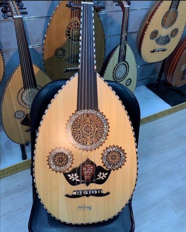 an intricately decorated guitar sits on display in a store window with other guitars behind it