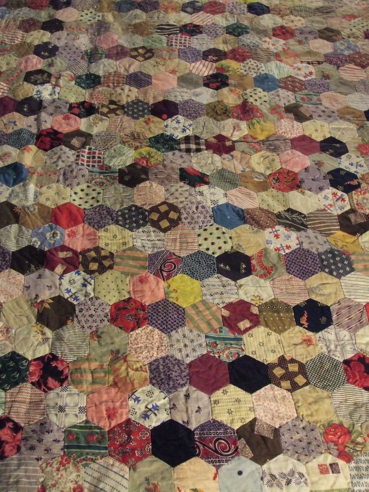 an old quilt that has been made into a bed spread with many different colors and patterns