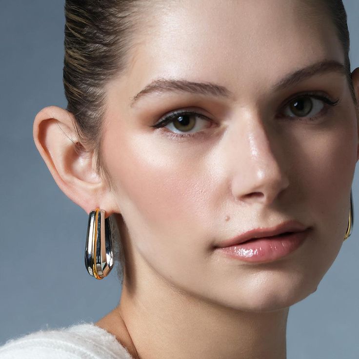 Create a striking look that commands the room with the Queen Ravenna Statement Hoops. Crafted in 925 sterling silver with 18K gold vermeil detailing, these hoops were made for the woman with an eye for opulence. Adorn yourself with these hoops and take on the world with enchanting royal elegance. Elegant Silver Tarnish-resistant Hoop Earrings, Elegant Tarnish Resistant Silver Hoop Earrings, Luxury Hoop Earrings For Evening, Modern Pierced Hoop Earrings For Evening, Elegant Polished Metal Hoop Earrings, Fine Jewelry Plated Hoop Earrings, Modern Hoop Jewelry For Parties, Luxury Hoop Earrings For Party, Elegant Small Hoop Earrings With Plating