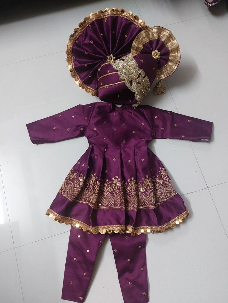 the doll is dressed in purple and gold