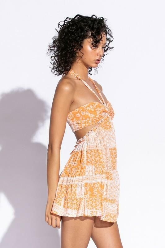 STYLE INFORMATION: Get your Texas boho vibes on in the Sundown Orange Patchwork Print Sundress!. Orange patchwork print woven fabric shapes this cute dress that has a halter V-neckline with tie straps, and a cutout waist.. The open back wraps around to the sides to create a cutout effect above the attached mini skirt. Ruffle trim and side ties decorate the cutout waist. DETAILS & CARE: Rayon/Polyester. Dry Clean. Imported. SHIPPING: Orders are processed within 1-2 business days. Packages are shi Chic Sundress With Crisscross Straps For Beach, Chic Summer Halter Top With Cutout, Chic Cutout Halter Top For Summer, Beach Sundress With Crisscross Straps, Cutout Halter Top For Beach In Summer, Summer V-neck Halter Top With Crisscross Straps, Beach Dresses With Crisscross Straps, Spring Beach Maxi Dress With Crisscross Straps, Tie Back Sundress For Picnic