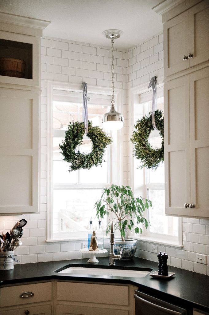 two wreaths hanging over a kitchen sink