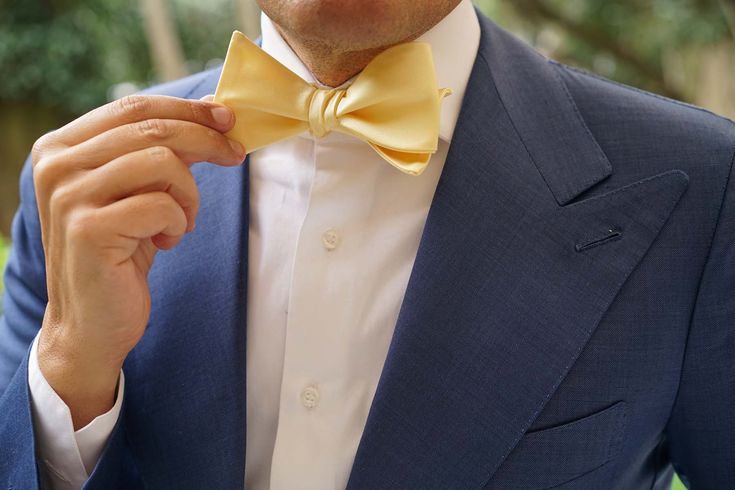 Master the art of elegance with OTAA's Light Yellow Satin Self Tie Bow Tie. Impeccably imbued with a delicate yellow palette, the simple design of this untied bow tie puts all the right emphasis on colour. A brilliant statement for weddings and important work meetings, this Light Yellow Satin Self Tie Bow Tie is as versatile as it is memorable. Let OTAA's signature hand-stitched approach give this handmade self tie bow tie an additional essence of luxury. Designed in-house and tailored b Elegant Formal Bow With Butterfly Knot, Yellow Fitted Bow Tie For Formal Occasions, Formal Yellow Bow Tie, Formal Yellow Fitted Bow Tie, Formal Fitted Yellow Bow Tie, Gold Elegant Bow With Tie Back, Elegant Yellow Bow Tie For Black Tie Events, Elegant Yellow Bow Tie For Formal Occasions, Classic Wedding Bow Tie With Bow Tie Back