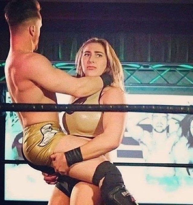 a man and woman in wrestling gear standing next to each other with their arms around each other