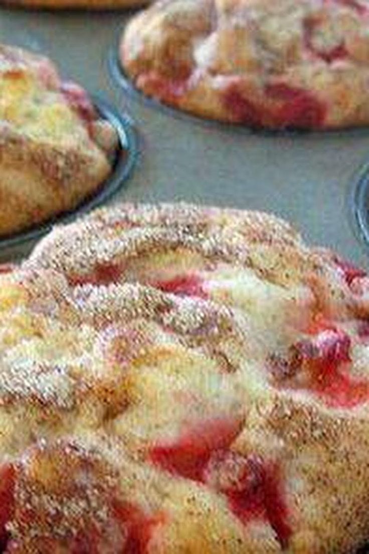 several pastries sitting in muffin tins with powdered sugar on them