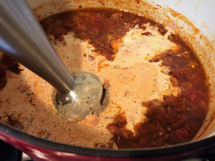 a large pot filled with some food and a ladle in the middle of it