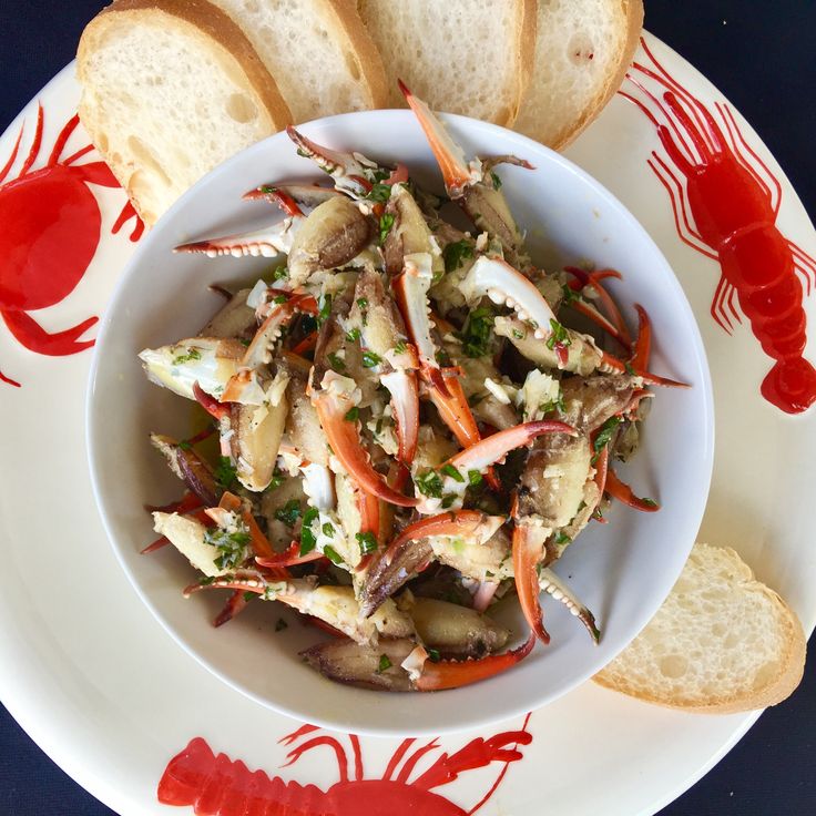 a white bowl filled with crab and bread