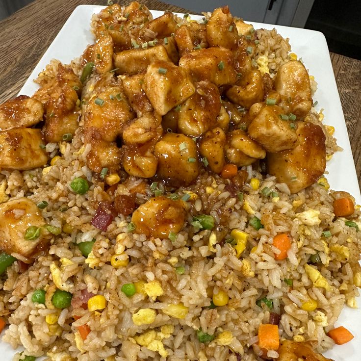 a white plate topped with rice and chicken