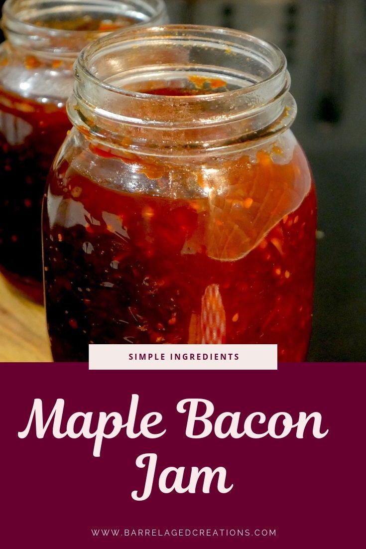 two jars filled with maple bacon jam sitting on top of a wooden table next to another jar