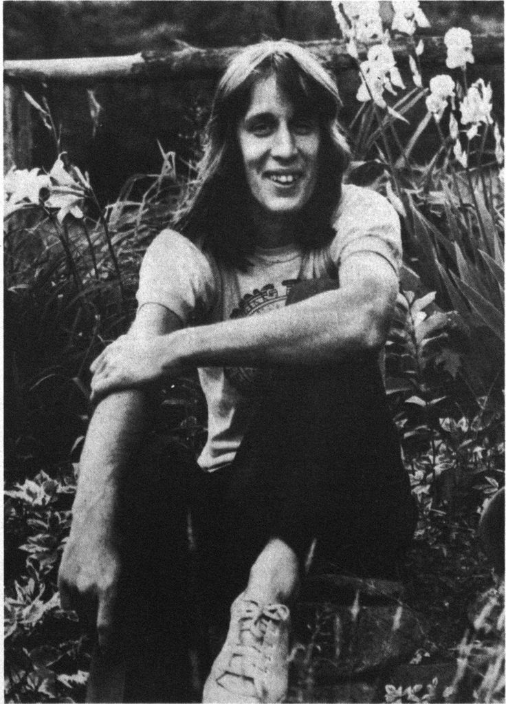 an old black and white photo of a person sitting on the ground