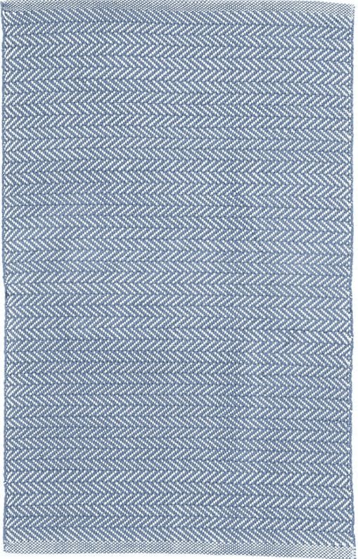 a blue and white rug with herrings on the bottom, in an angled pattern