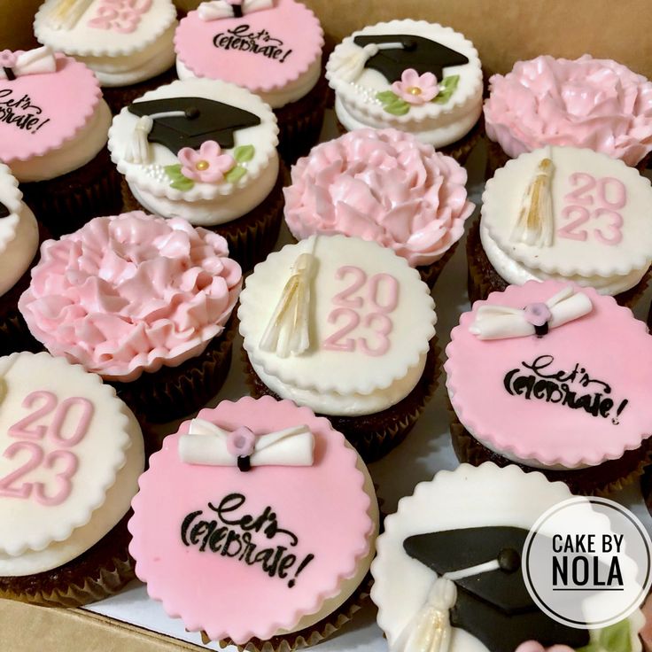 cupcakes decorated with pink and white frosting in a box