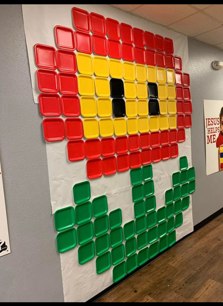 an office cubicle decorated with legos and plastic cups on the wall, as well as posters