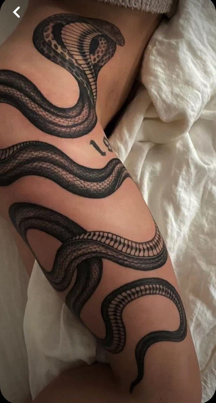 a woman's thigh with a snake tattoo on it