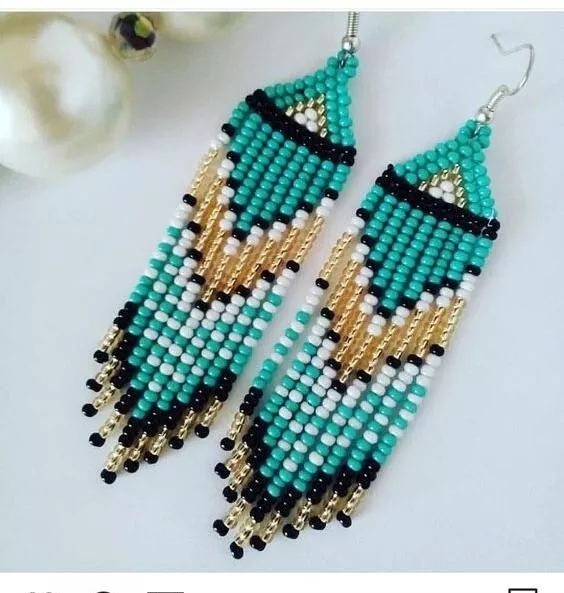 a pair of beaded earrings sitting on top of a table