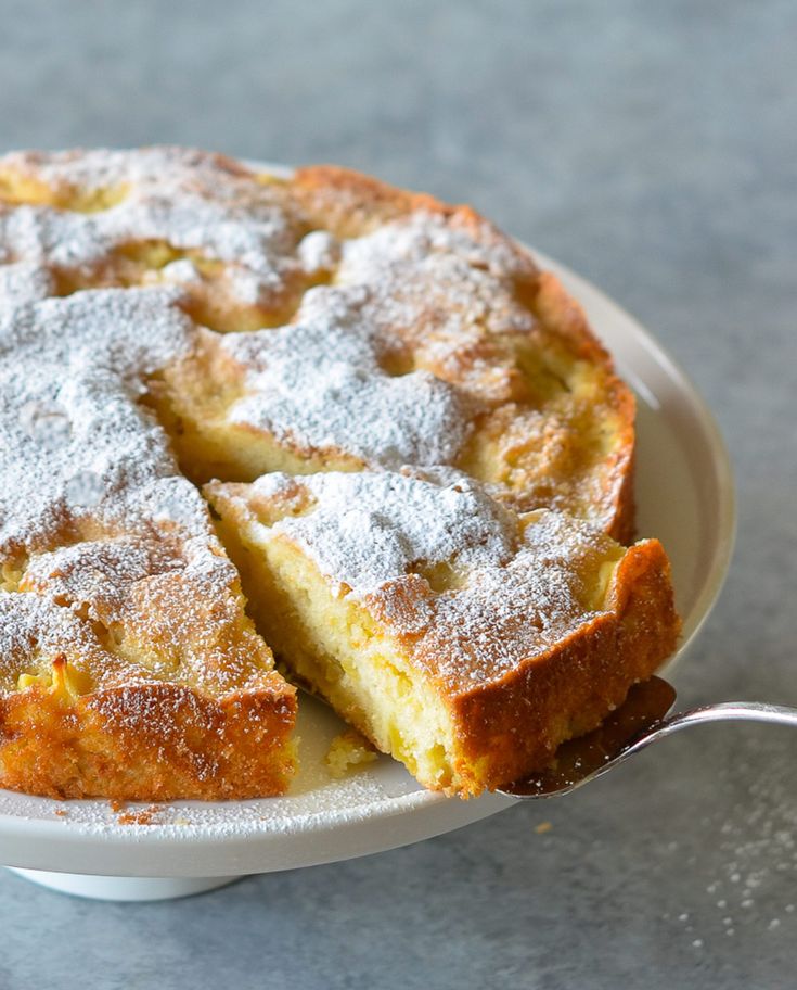 a cake sitting on top of a white plate covered in powdered sugar