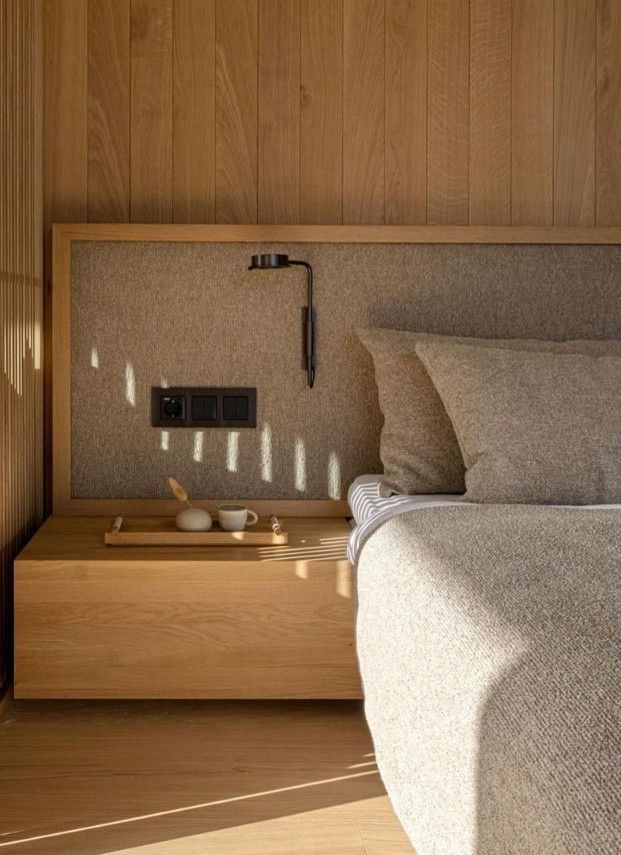 a bed sitting next to a wooden wall