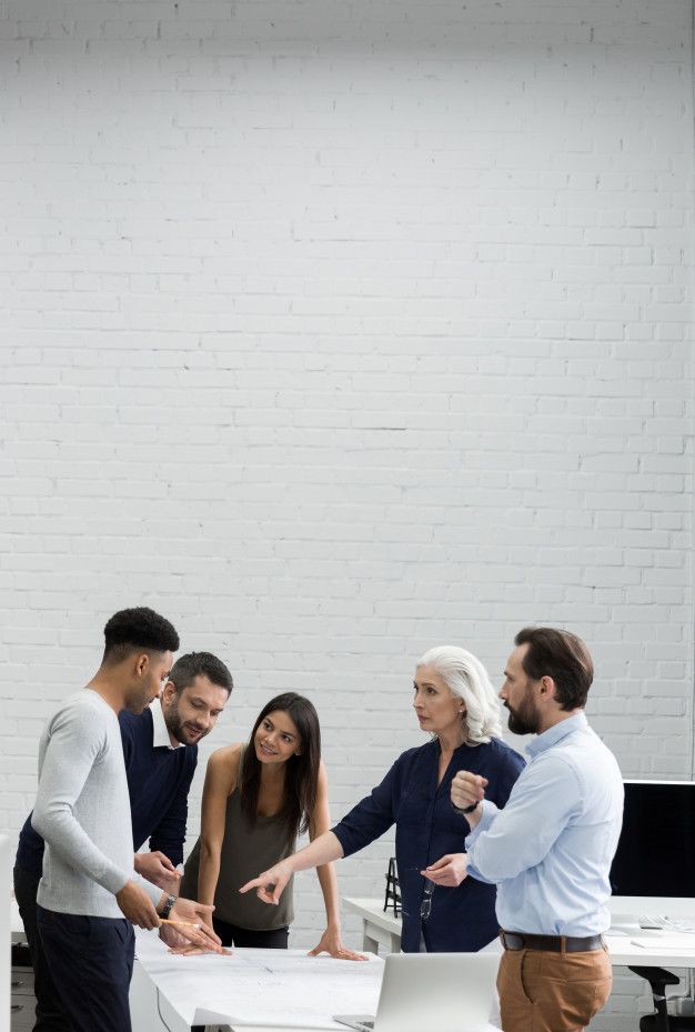 group of people standing around a table in an office