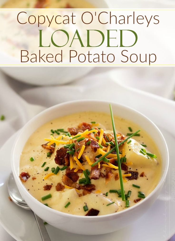 a bowl of baked potato soup with cheese and bacon on top, sitting on a plate