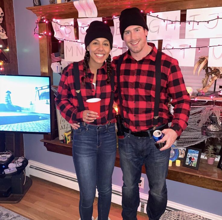 a man and woman standing next to each other in front of a flat screen tv