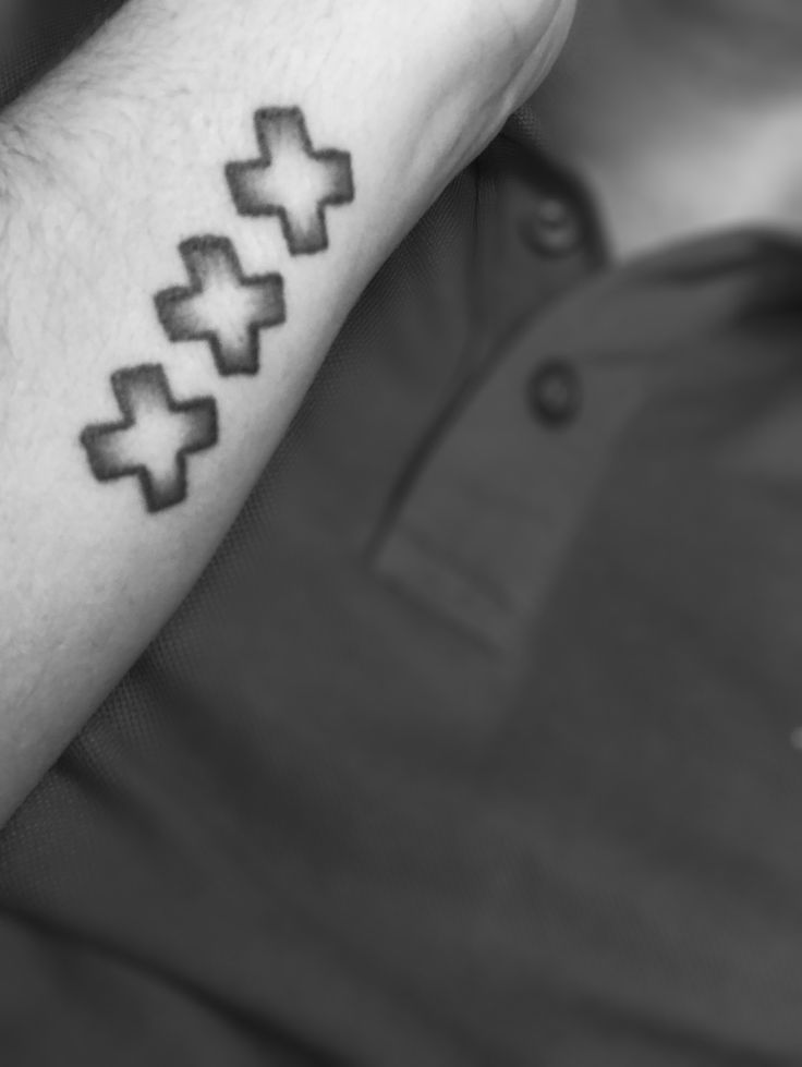 a man with a cross tattoo on his arm