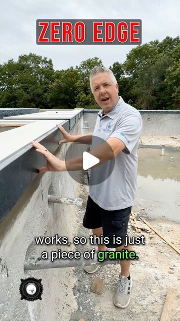 a man standing on top of a building next to a sign that reads zero edge works, so this is just a piece of granite