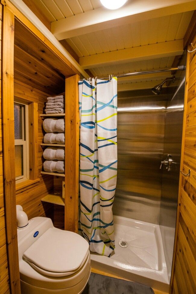 a bathroom with a toilet, tub and shower in it's wood paneled walls