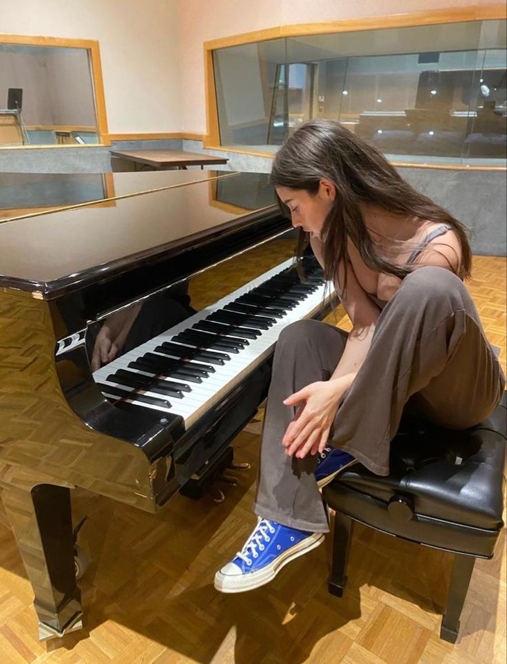 a woman sitting on a chair next to a piano