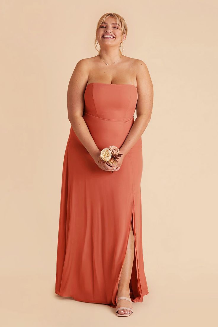 a woman in an orange dress is smiling