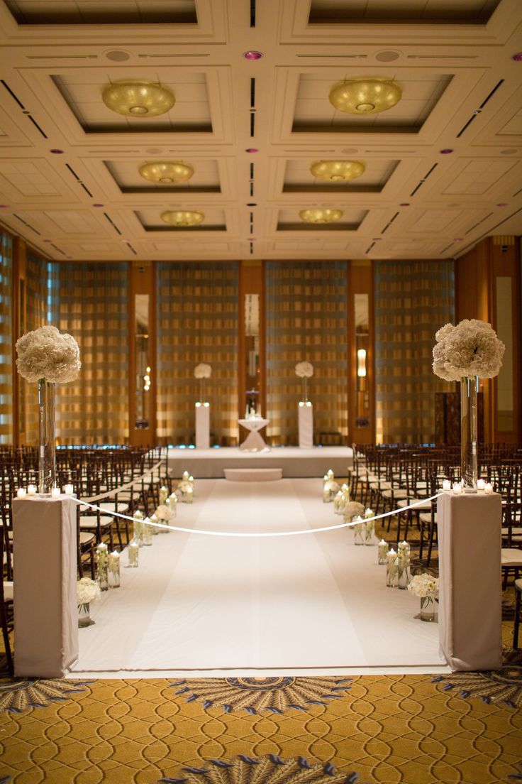 the aisle is lined with white flowers and candles