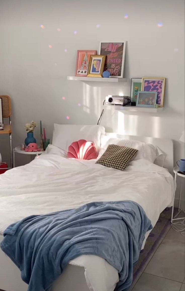 a white bed sitting in a bedroom on top of a hard wood floor