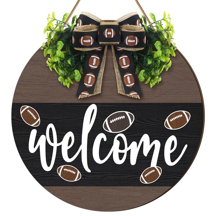 a welcome sign with footballs and greenery hanging from it's center piece