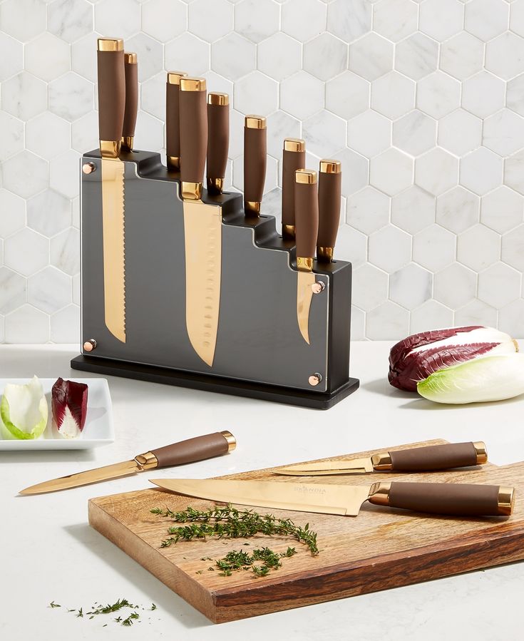 a knife holder with knives and cutting boards on a counter top next to other kitchen items