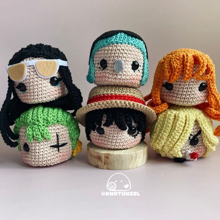 four crocheted dolls sitting next to each other