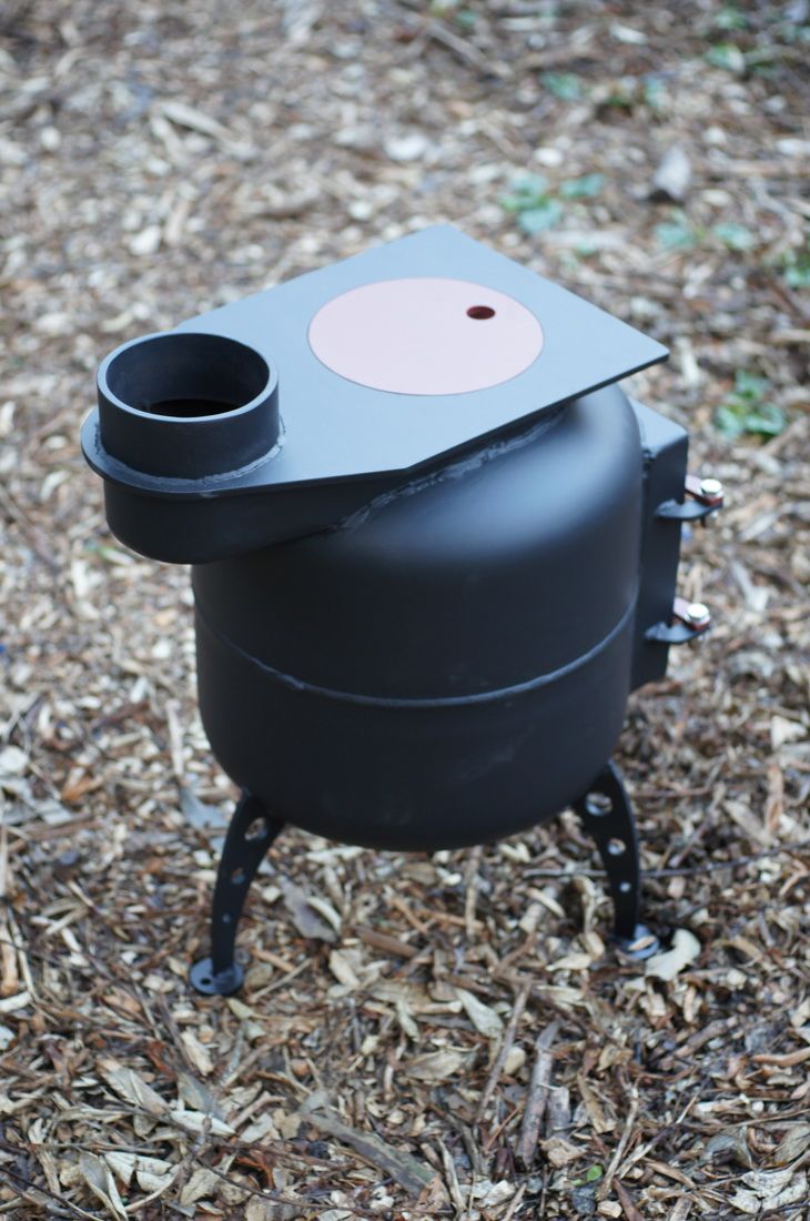 a black stove sitting on top of dry grass