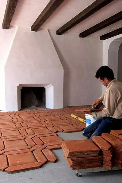 a man sitting on top of a pile of red bricks next to a fire place