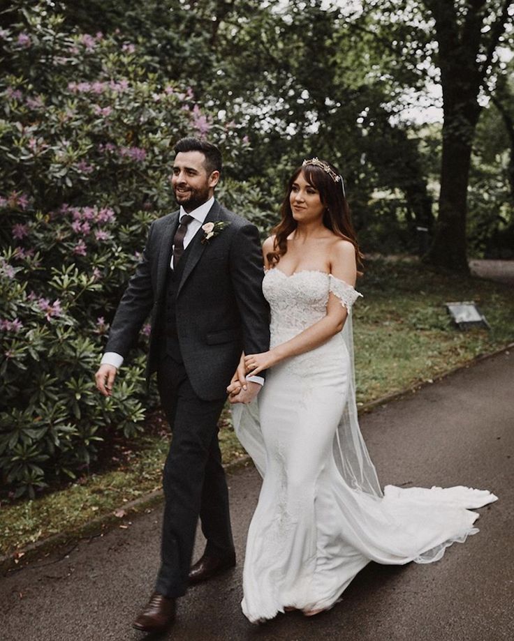 a bride and groom walking down the road