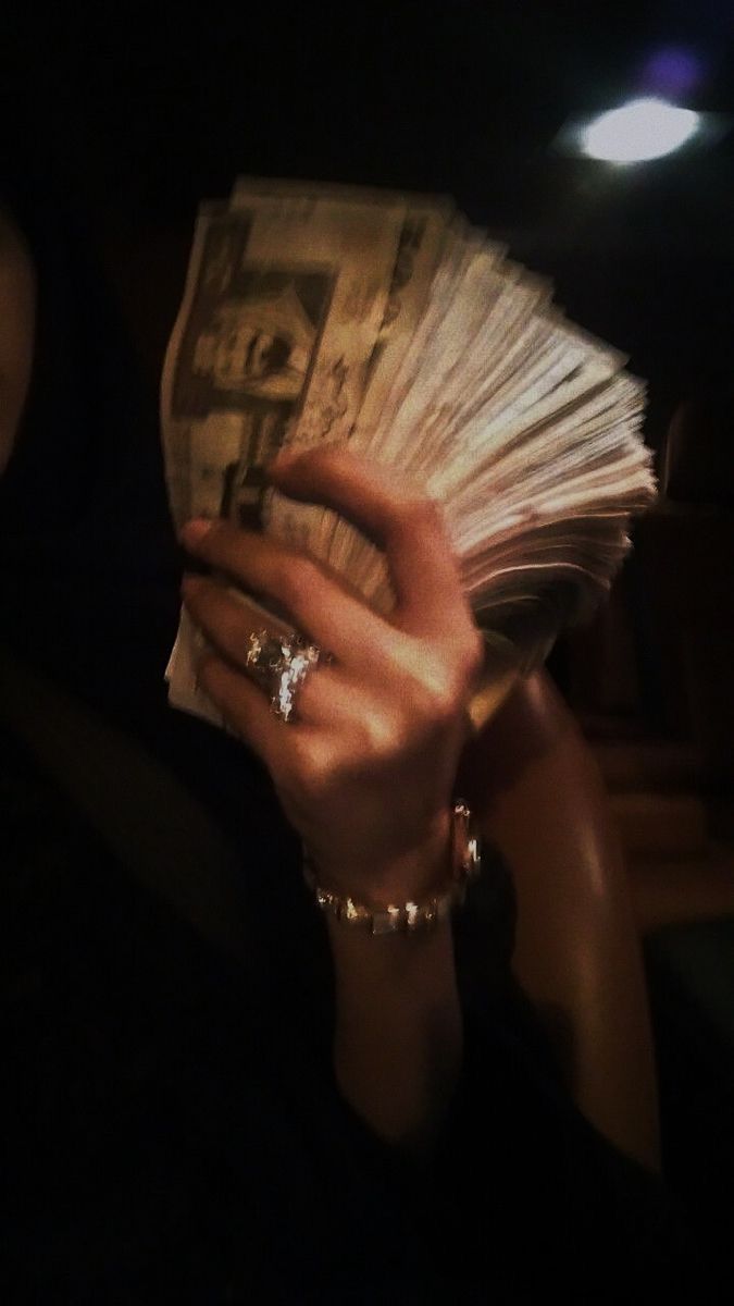 a woman is holding cash in her hand