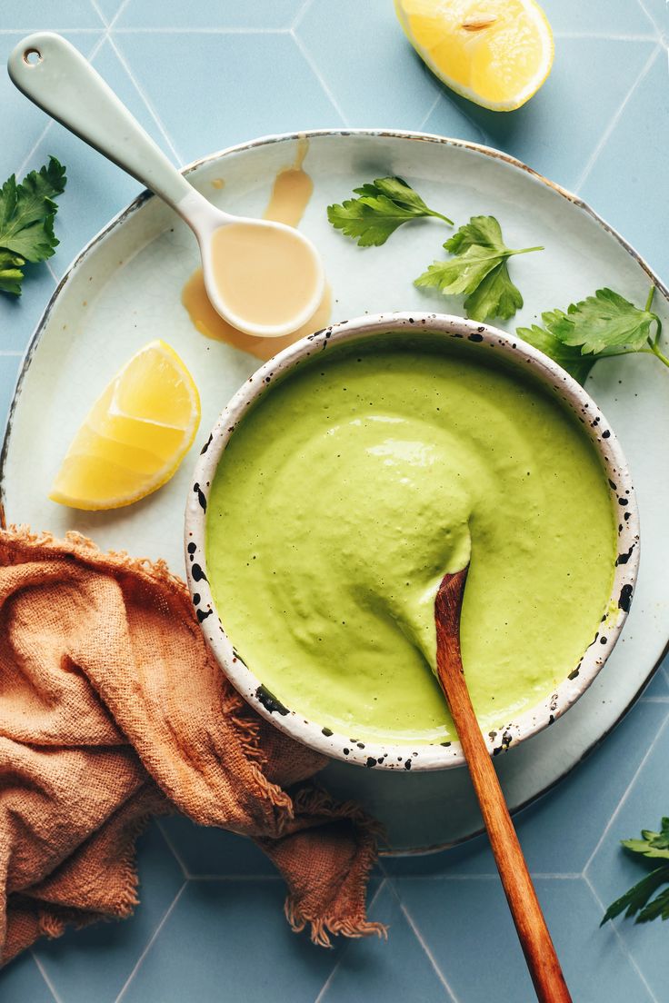 a bowl filled with avocado and garnish next to sliced lemons