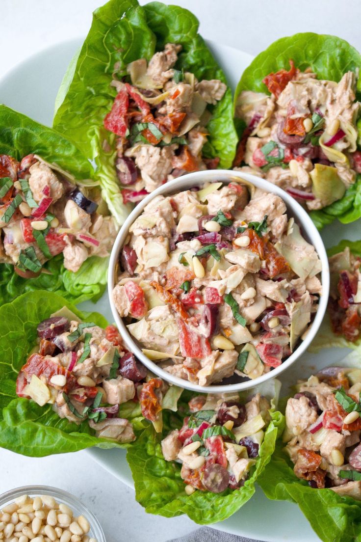 lettuce wraps filled with chicken salad on top of a white plate