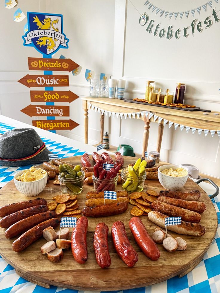 a wooden platter filled with sausages, potatoes and other foods on top of a blue and white checkered table cloth