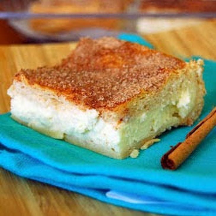 a piece of cake sitting on top of a blue napkin next to cinnamon sticks and an apple