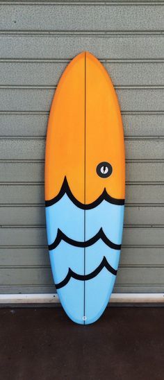 a blue and yellow surfboard sitting on top of a garage door