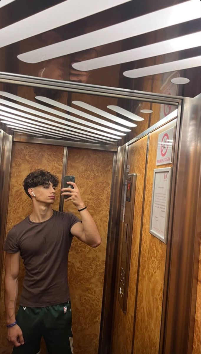 a man taking a selfie in an elevator