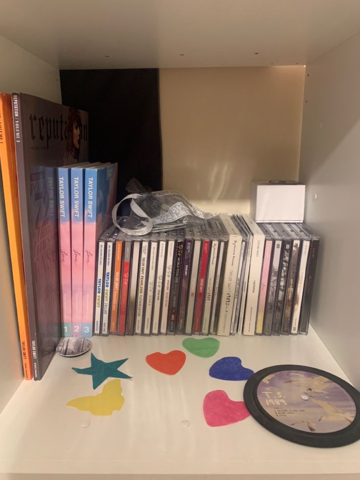 there are many dvds and cds on the shelf next to each other in this room