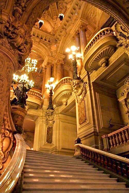 an ornate staircase with chandeliers and lights